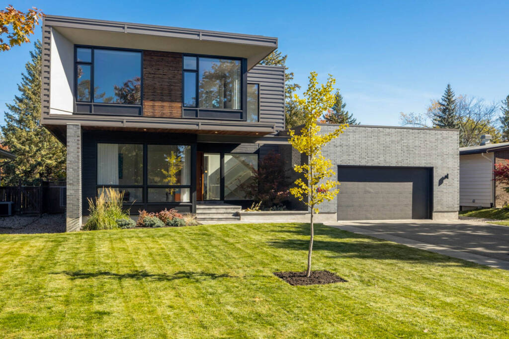 CrystalCrest Inc landscapers maintaining the front yard of a contemporary house.