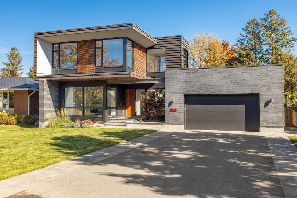 CrystalCrest Inc team expertly mowing the front yard of a modern house.