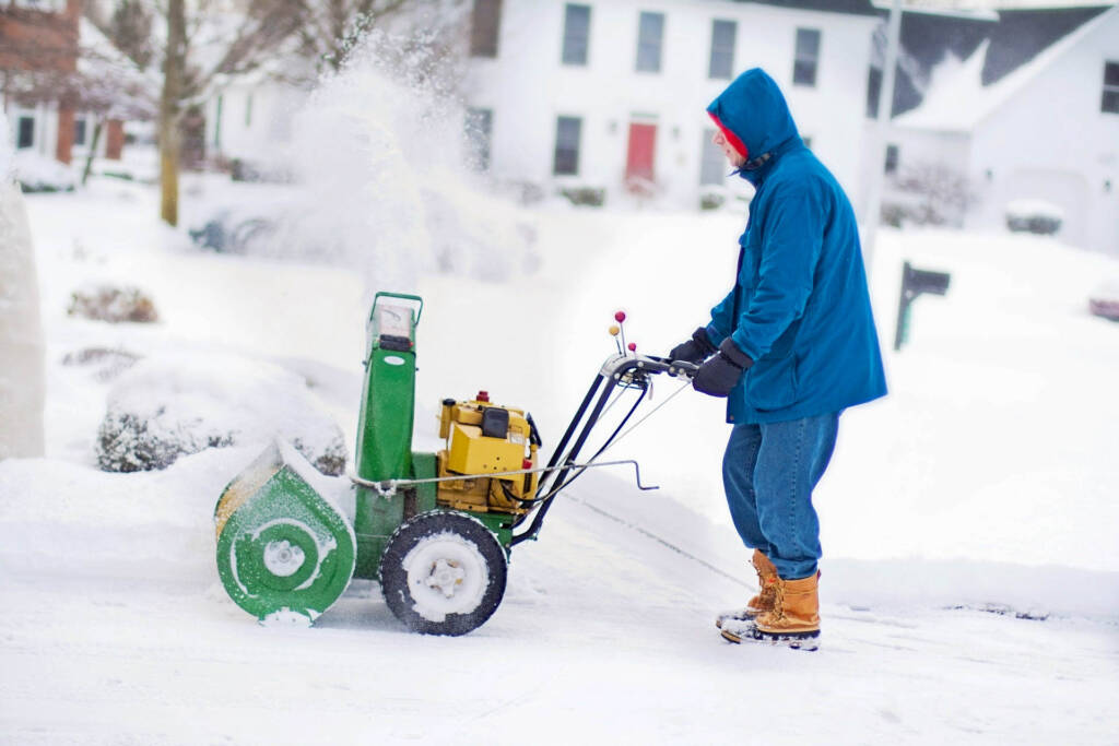 CrystalCrest Inc clearing snow in a parking area.